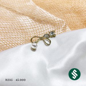 Khuyên tai không đối xứng hai bên, dáng nơ to đính ngọc và bên còn lại là đá xanh sáng bóng lạ mắt B235