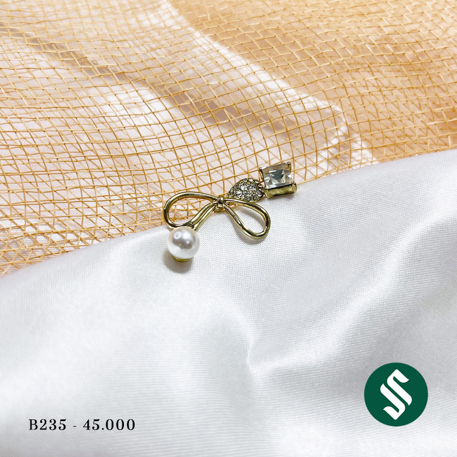 Khuyên tai không đối xứng hai bên, dáng nơ to đính ngọc và bên còn lại là đá xanh sáng bóng lạ mắt B235